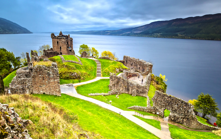 Urquhart Castle mit Dark Cloud Sky und Loch Ness im Hintergrund