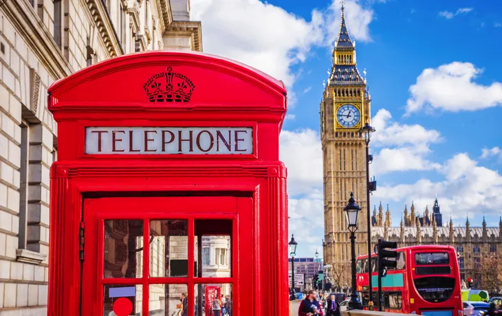 traditionelle rote britische Telefonzelle mit Big Ben und Doppeldeckerbus im Hintergrund in London